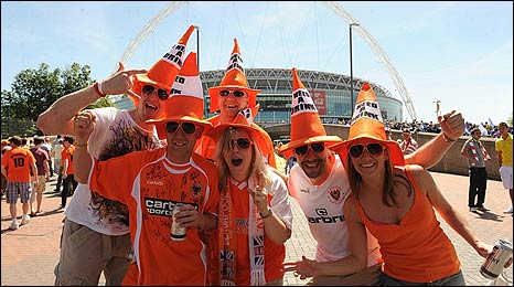 A group of Blackpool fans dressed in orange traffic-cone hats with cans of beer outside the new Wembley stadium before the 2010 Coca Cola Championship play off final against Cardiff