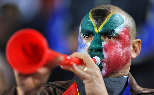 A fan with South Africa face-paint blowing a vuvuzela, the horn from the 2010 South Africa World Cup (vuvuzelas)