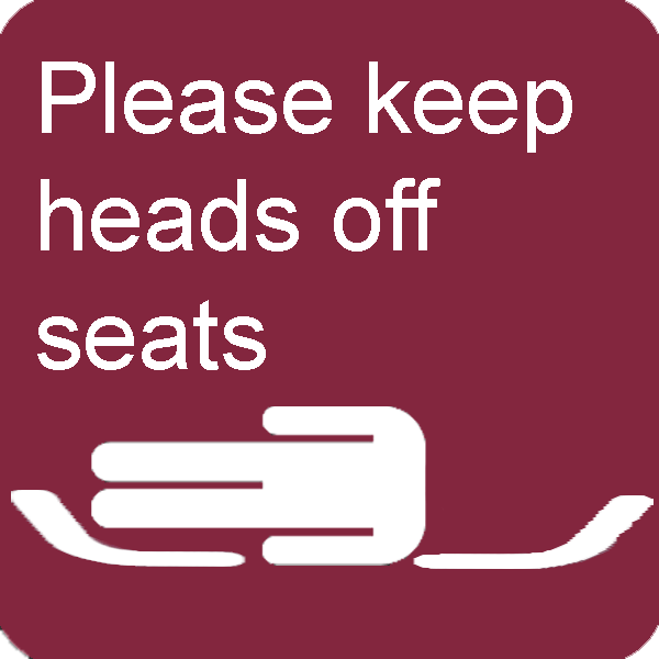 a sign exhorting rail passengers to keep their heads off seats