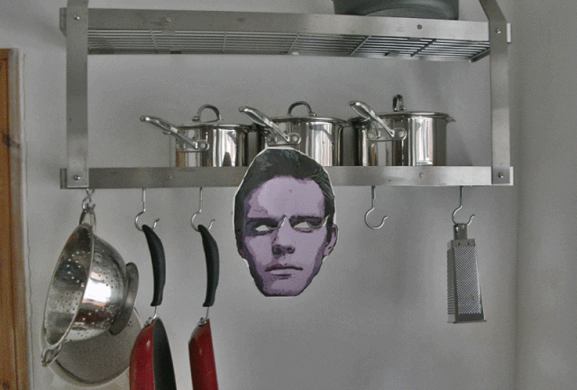 A scary Jonathan Lee mask hanging from a pan rack