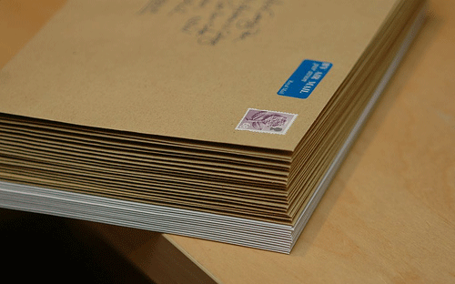 A stack of envelopes with stamps affixed ready to be dispatched